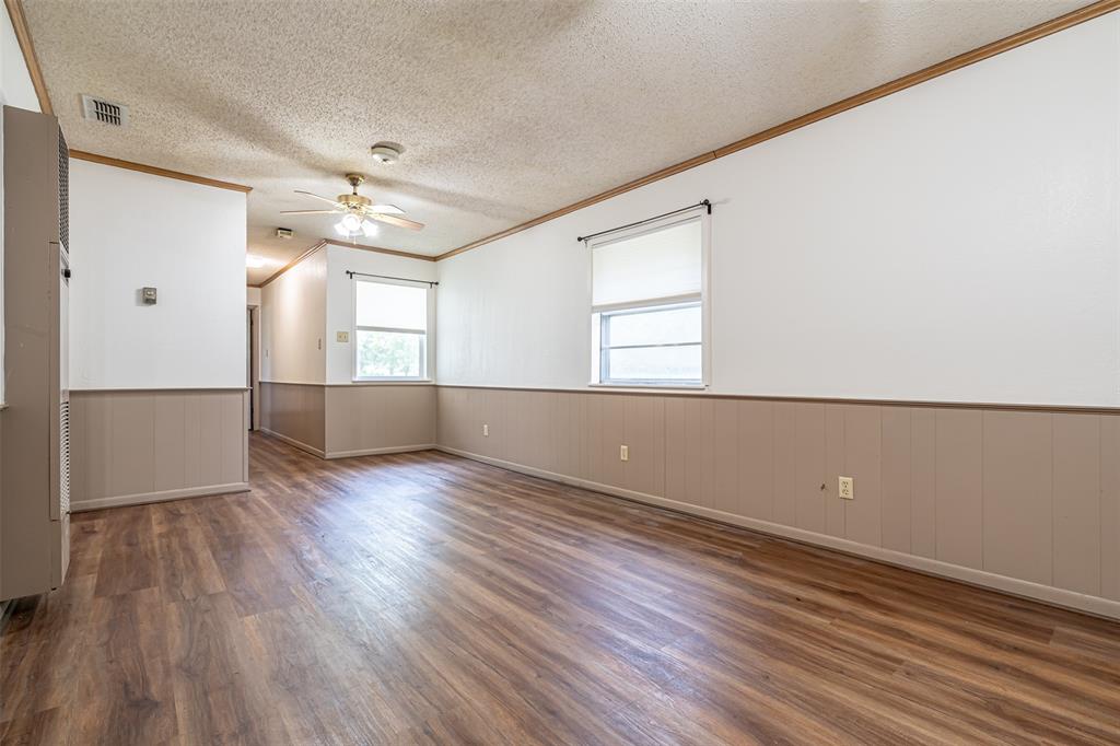 501 Endora Dublin, TX 76446 - Photo 10 of 39 an empty room with wooden floor and windows