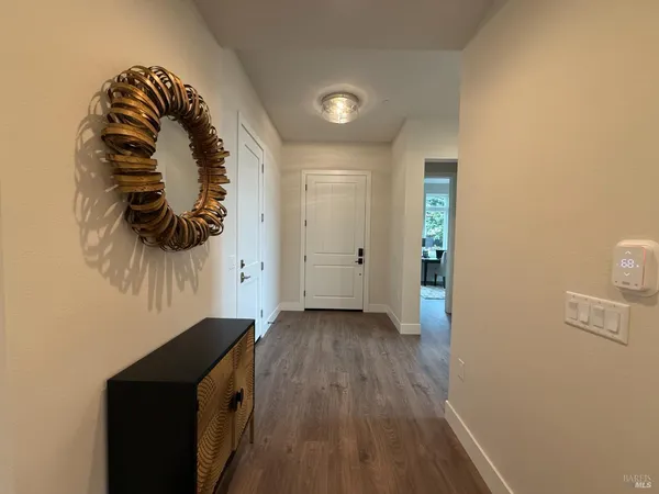 a view of a hallway with wooden floor and a fireplace