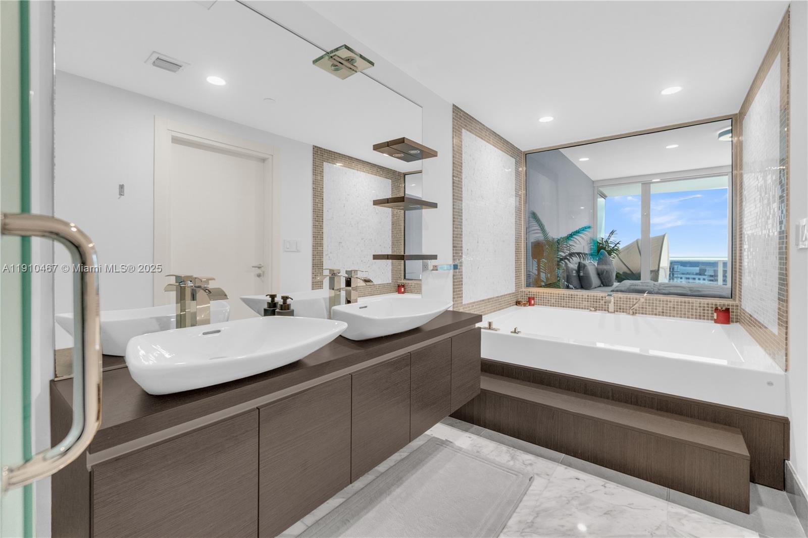 200 Biscayne Blvd Way, Unit 3907 Miami, FL 33131 - Photo 16 of 46 a bathroom with a bathtub a double vanity sink and mirror