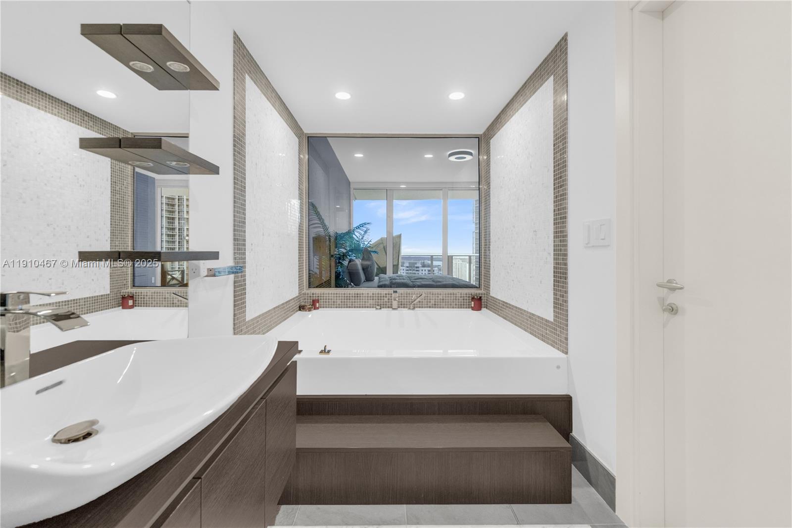 200 Biscayne Blvd Way, Unit 3907 Miami, FL 33131 - Photo 17 of 46 a large white kitchen with a sink and a large mirror