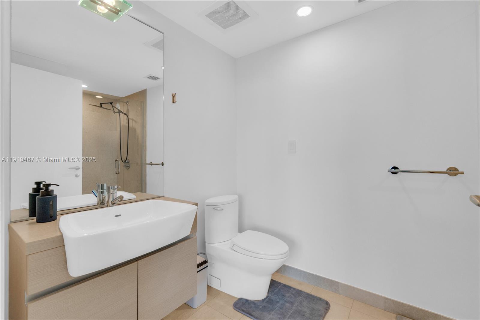 200 Biscayne Blvd Way, Unit 3907 Miami, FL 33131 - Photo 23 of 46 a bathroom with a sink a toilet and mirror