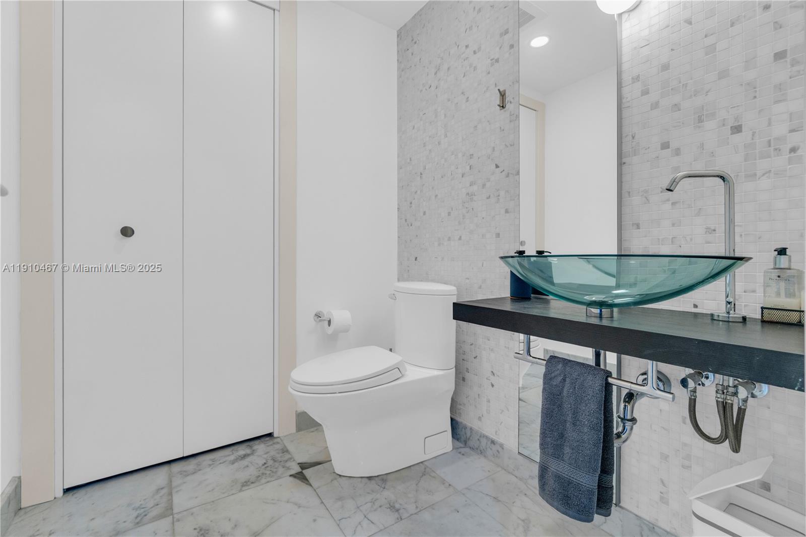 200 Biscayne Blvd Way, Unit 3907 Miami, FL 33131 - Photo 43 of 46 a bathroom with a granite countertop sink a toilet and mirror