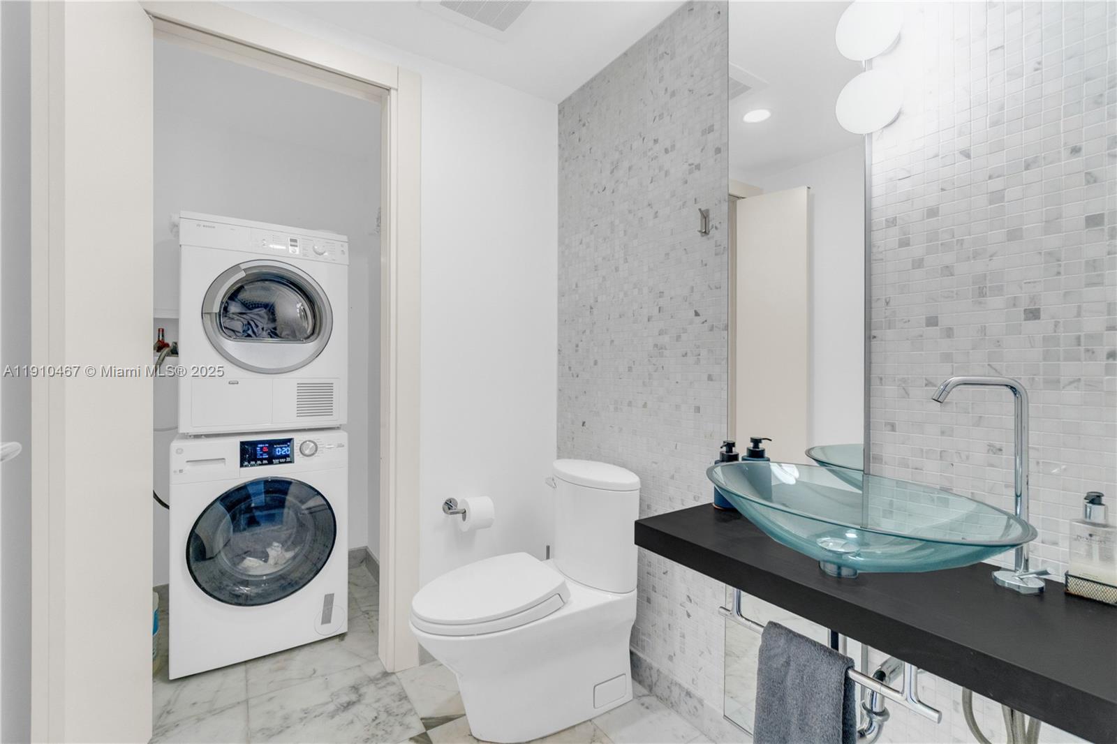 200 Biscayne Blvd Way, Unit 3907 Miami, FL 33131 - Photo 44 of 46 a bathroom with a sink a toilet and a mirror