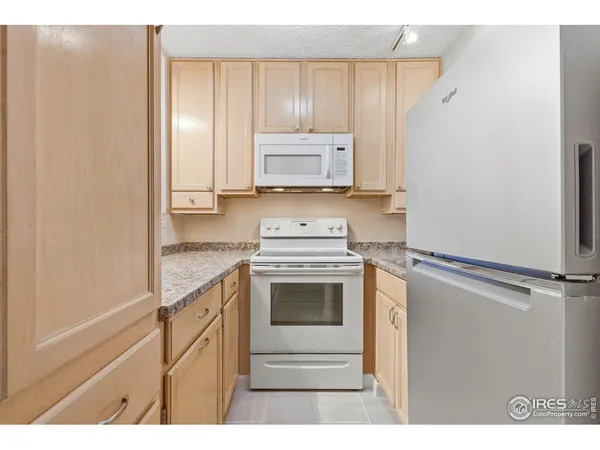 a kitchen with granite countertop white cabinets and stainless steel appliances