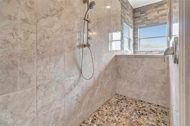 a view of a hallway with wooden floor and a bathroom
