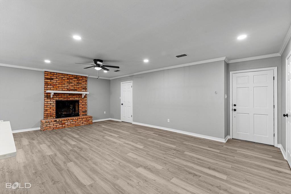 6016 Fox Ridge Shreveport, LA 71129 - Photo 14 of 33 a view of an empty room with wooden floor fireplace and a window