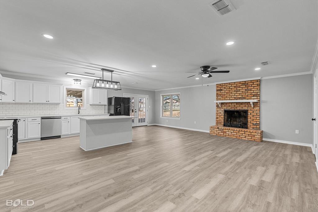 6016 Fox Ridge Shreveport, LA 71129 - Photo 15 of 33 a living room with stainless steel appliances kitchen island a large counter top and a fireplace
