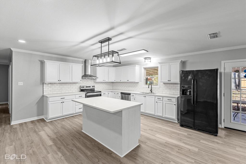 6016 Fox Ridge Shreveport, LA 71129 - Photo 20 of 33 a kitchen with a sink a refrigerator and white cabinets