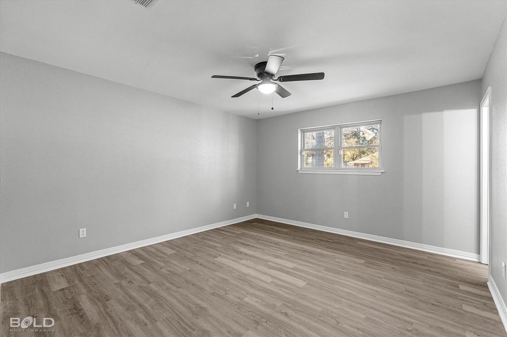 6016 Fox Ridge Shreveport, LA 71129 - Photo 26 of 33 an empty room with wooden floor ceiling fan and windows