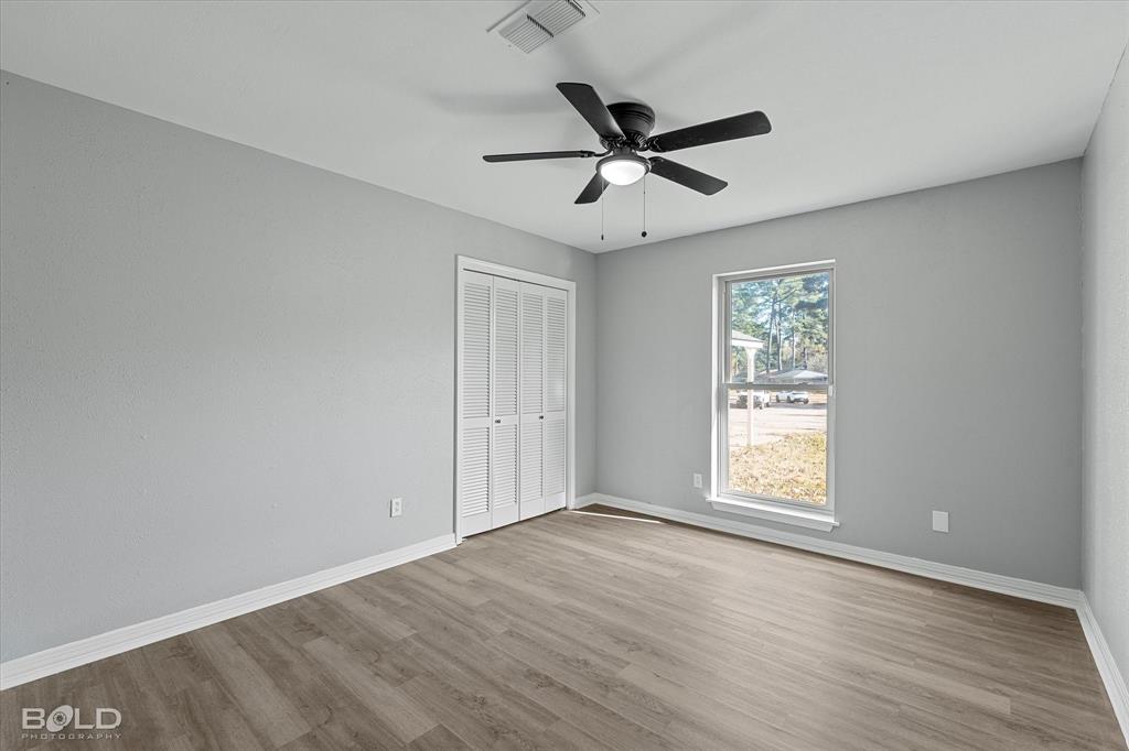 6016 Fox Ridge Shreveport, LA 71129 - Photo 32 of 33 an empty room with wooden floor fan and windows