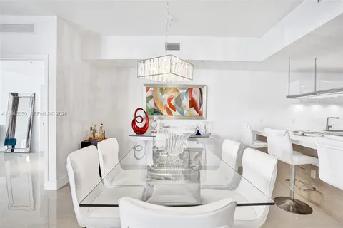 a dining room with furniture a large window and kitchen view