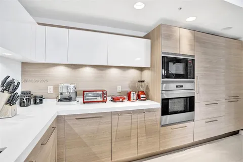 a kitchen with kitchen island stainless steel appliances a sink and cabinets