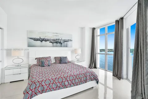 a bedroom with a bed and a large window