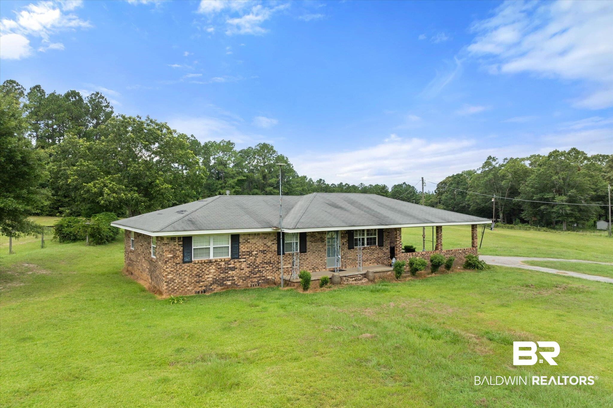 11601 Lott Road Chunchula, AL 36521 - Photo 16 of 34 Single story home with covered porch, brick siding, a front lawn, and driveway