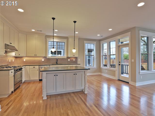 2437 North Alberta Street Portland, OR 97217 - Photo 5 of 16 a large kitchen with granite countertop a large counter top space a sink stainless steel appliances and cabinets