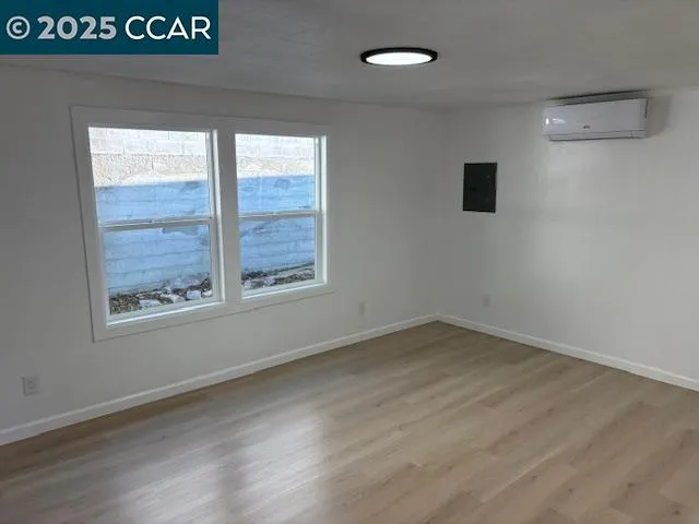 a view of empty room with window and wooden floor