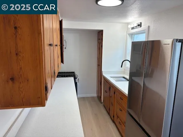 a kitchen with stainless steel appliances granite countertop a refrigerator and a sink