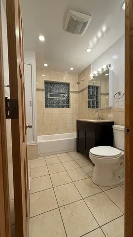 a bathroom with a sink a toilet a mirror and shower