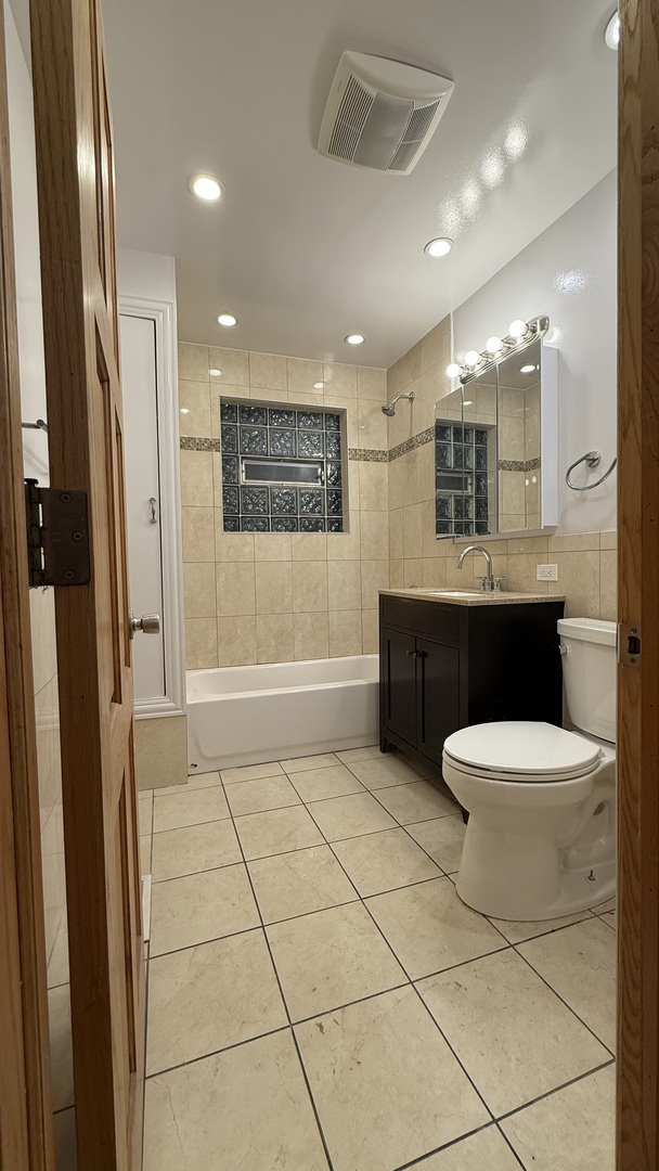 2216 North Central Avenue, Unit 1 Chicago, IL 60639 - Photo 16 of 28 a bathroom with a sink a toilet a mirror and shower