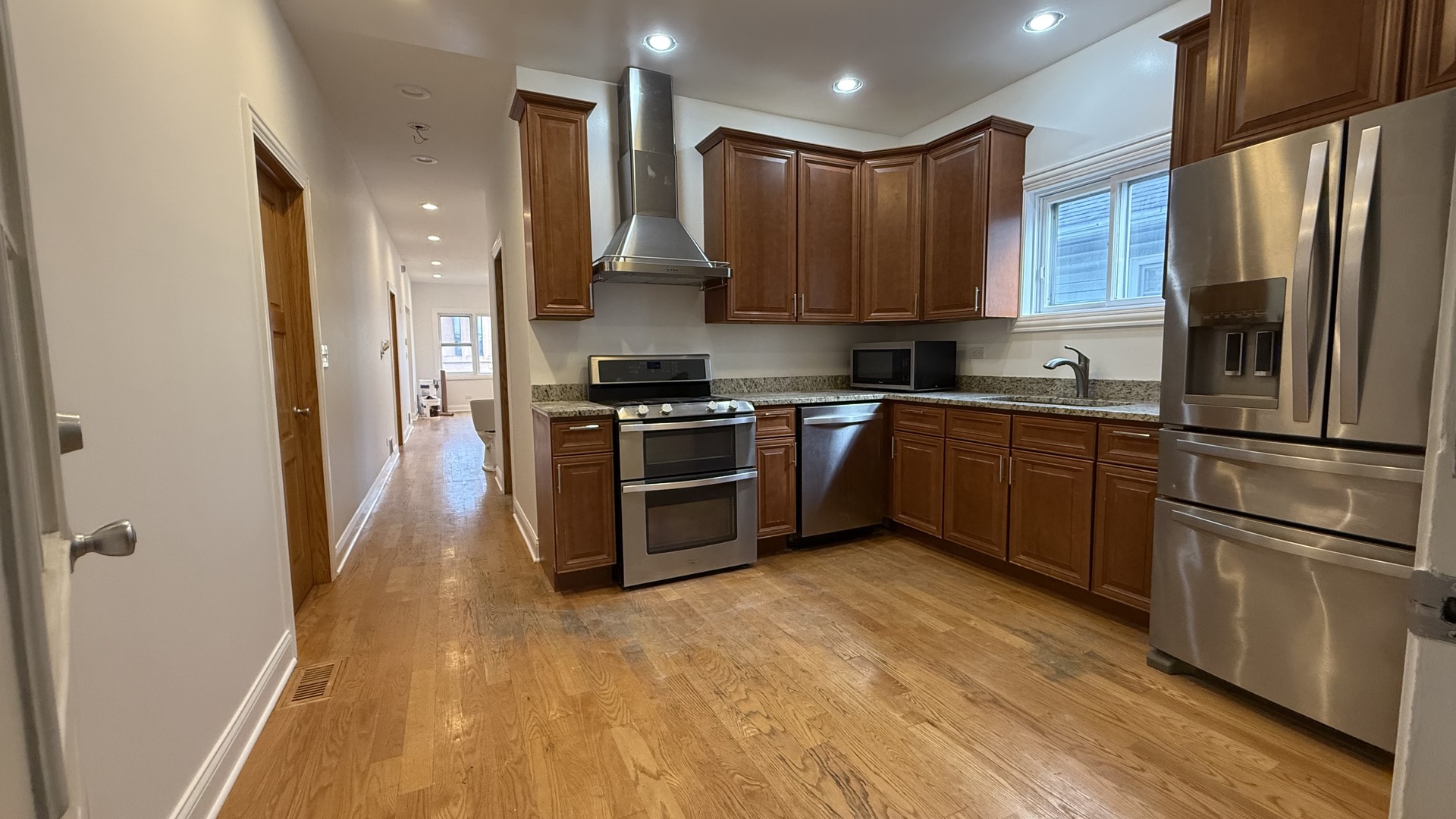2216 North Central Avenue, Unit 1 Chicago, IL 60639 - Photo 18 of 28 a kitchen with stainless steel appliances granite countertop a refrigerator a sink dishwasher a stove and a microwave oven on granite countertops