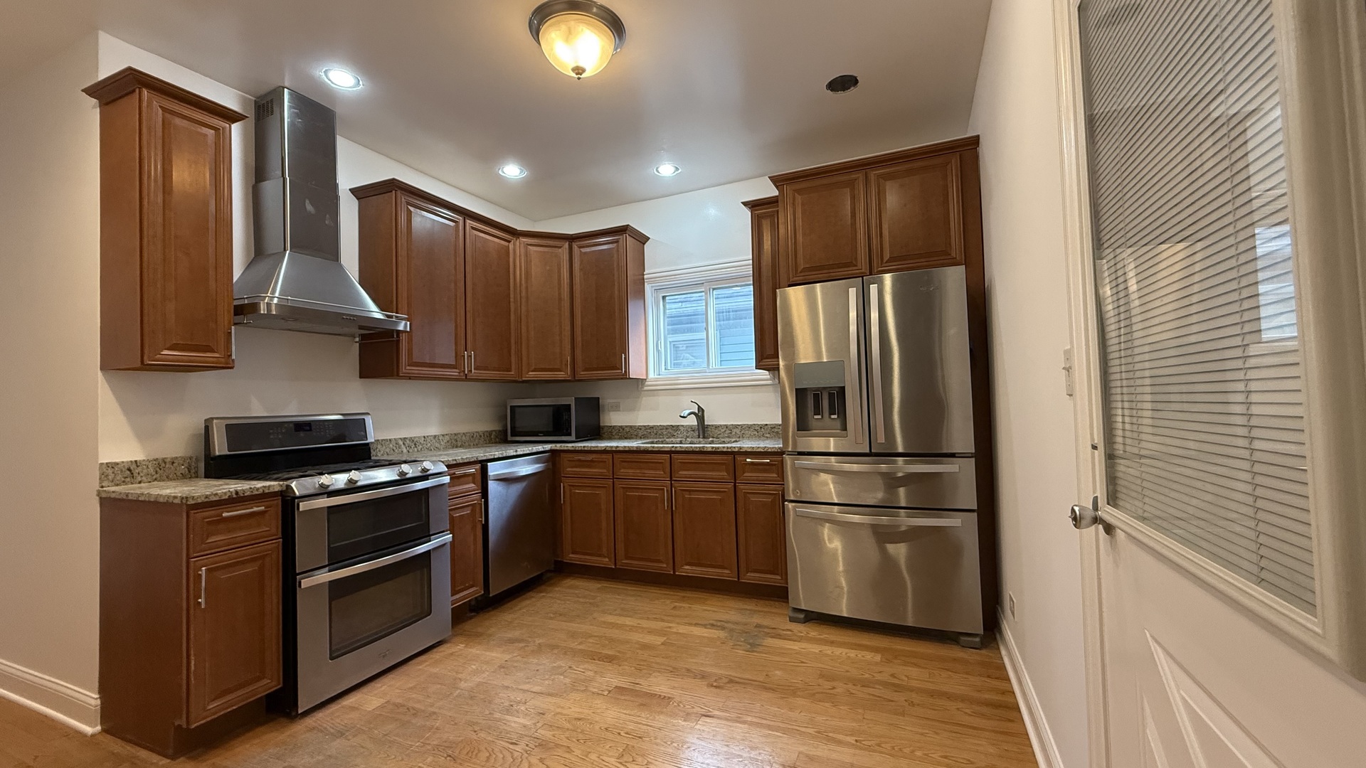 2216 North Central Avenue, Unit 1 Chicago, IL 60639 - Photo 23 of 28 a kitchen with stainless steel appliances granite countertop a refrigerator stove and sink