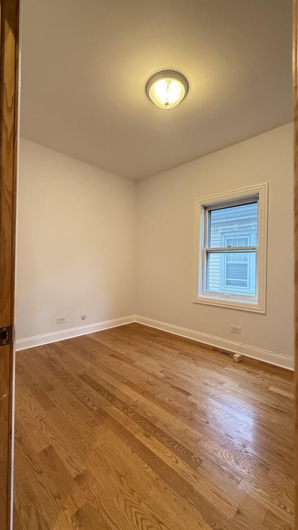 2216 North Central Avenue, Unit 1 Chicago, IL 60639 - Photo 9 of 28 wooden floor in an empty room with a window