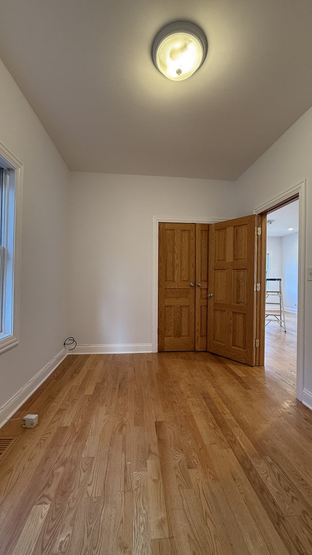 2216 North Central Avenue, Unit 1 Chicago, IL 60639 - Photo 10 of 28 an empty room with wooden floor and windows