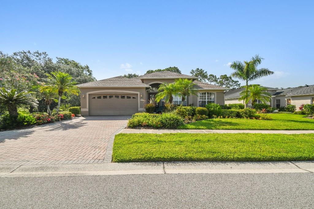 a front view of a house with a garden and trees