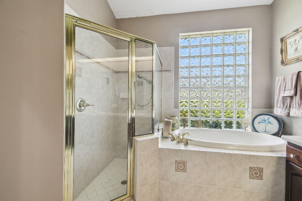 3402 Stonebridge Trail Valrico, FL 33596 - Photo 14 of 17 a bathroom with a granite countertop sink a mirror and a bathtub
