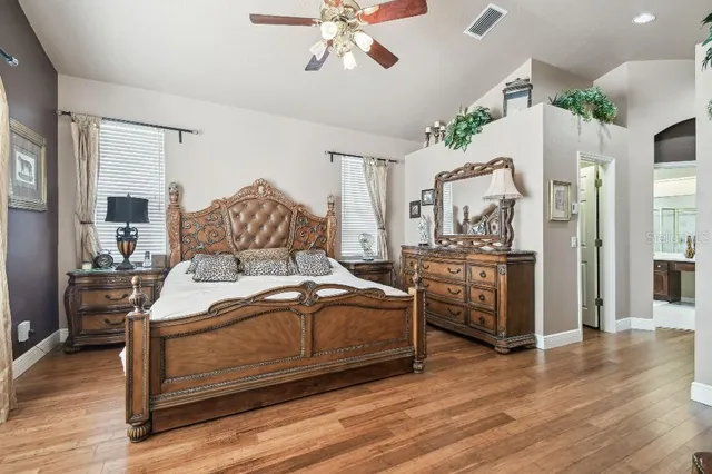 a bedroom with a bed and wooden floor