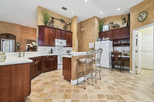 a kitchen with stainless steel appliances kitchen island granite countertop a sink and cabinets