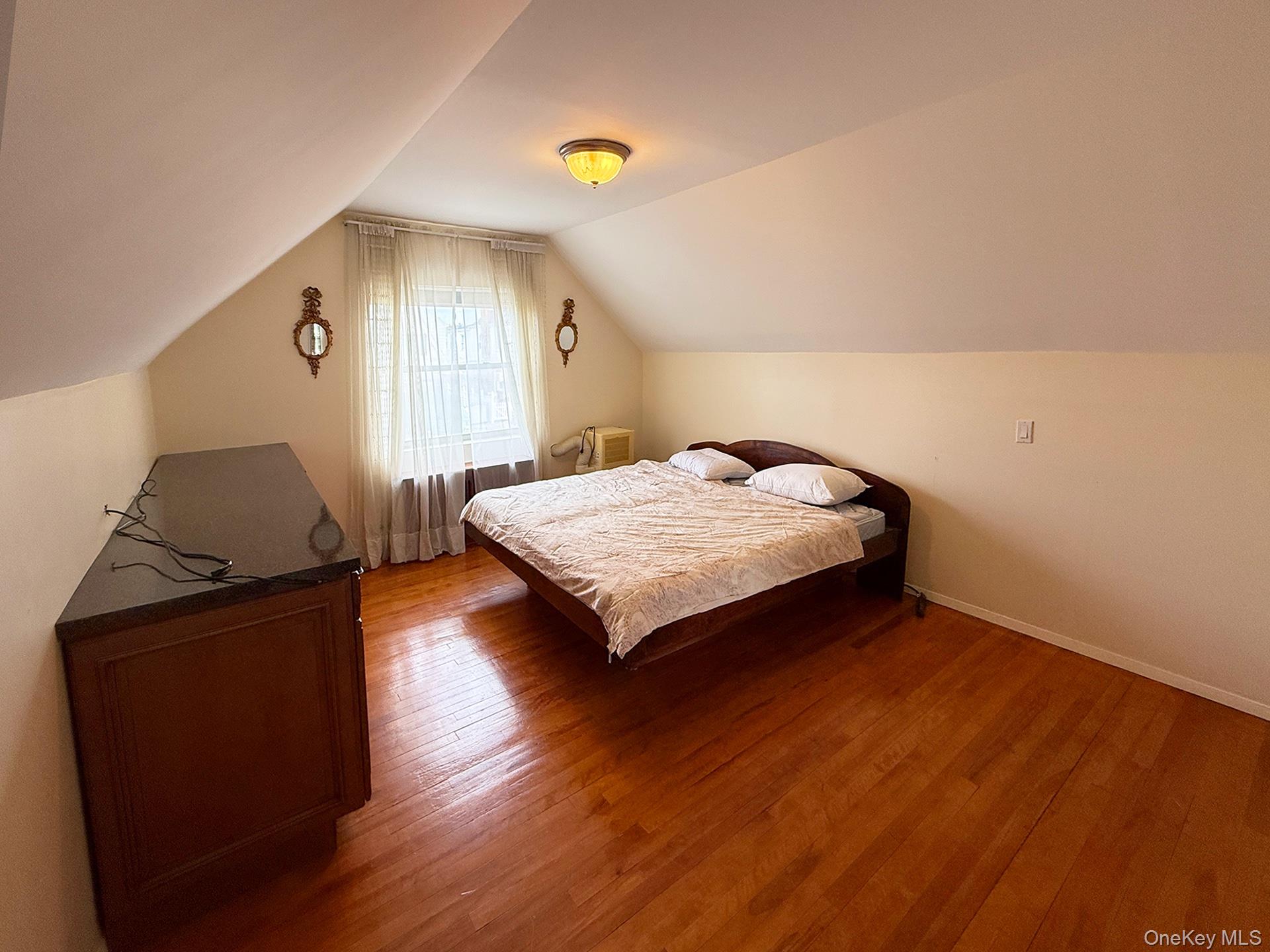 48-22 195th Street Queens, NY 11365 - Photo 11 of 23 a bedroom with a bed and wooden floor