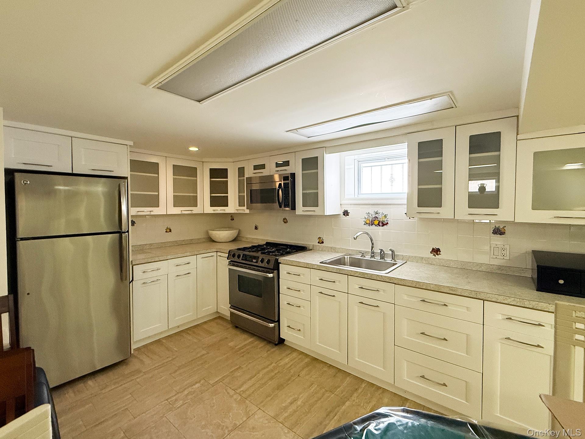 48-22 195th Street Queens, NY 11365 - Photo 18 of 23 a kitchen with stainless steel appliances granite countertop a refrigerator a sink dishwasher a stove with white cabinets and wooden floor