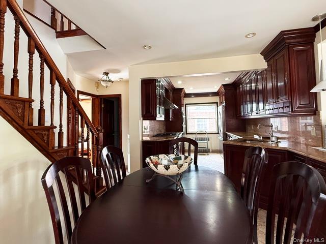 48-22 195th Street Queens, NY 11365 - Photo 19 of 23 a kitchen with stainless steel appliances granite countertop a refrigerator a stove a sink dishwasher and a dining table with wooden floor