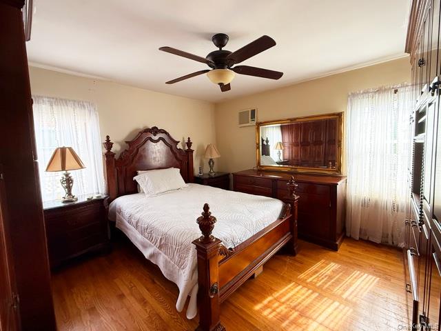 48-22 195th Street Queens, NY 11365 - Photo 7 of 23 a bed room with a bed and a chandelier