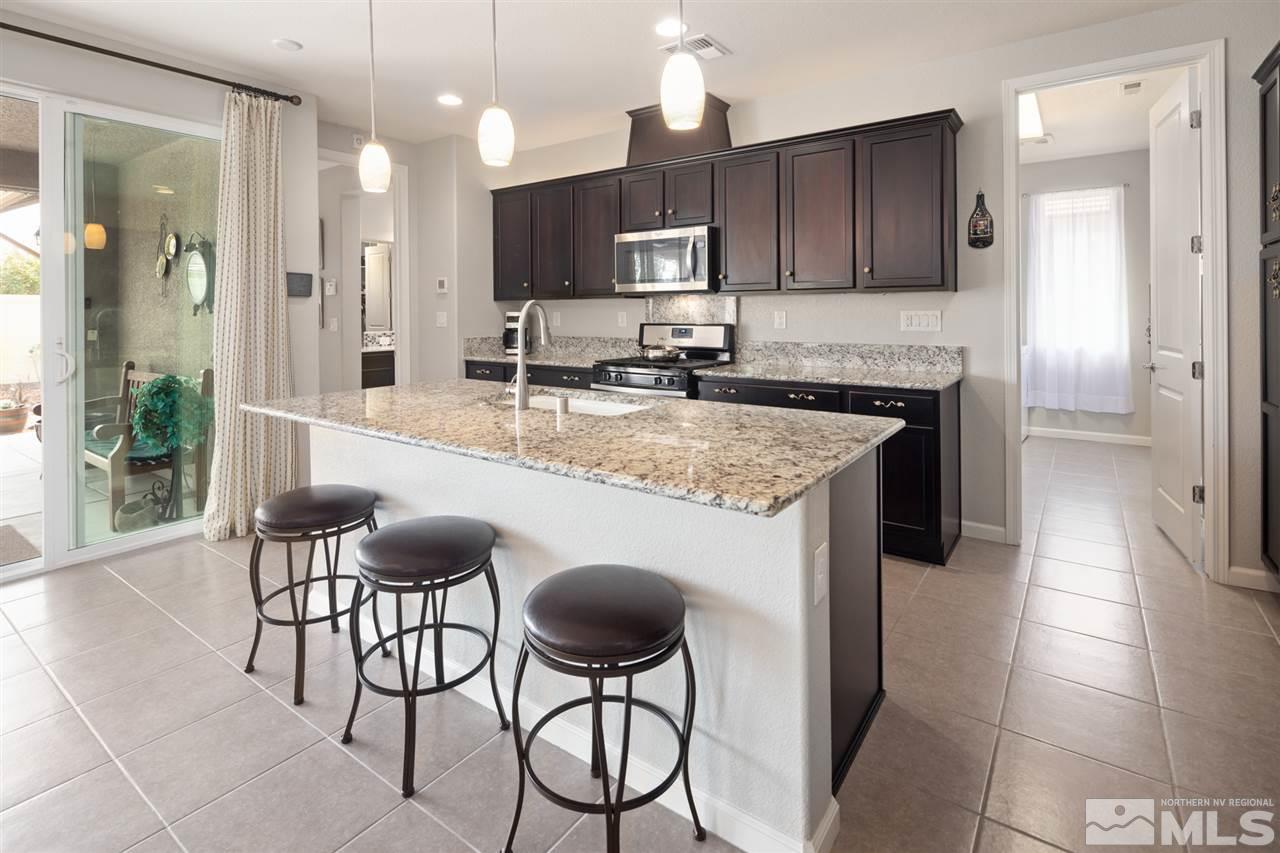 9850 Shadowless Trail Reno, NV 89521 - Photo 36 of 39 a large kitchen with stainless steel appliances granite countertop a stove a sink and a microwave