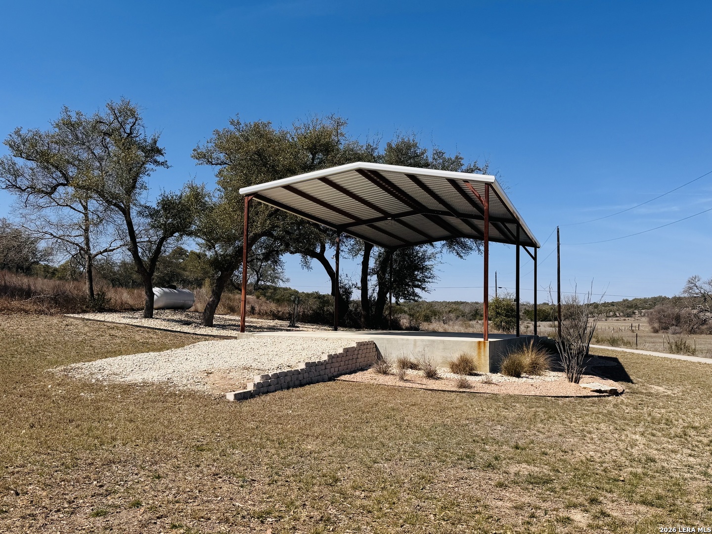 451 Wegener Trail Fischer, TX 78623 - Photo 25 of 43 a view of a backyard with table and chairs under an umbrella