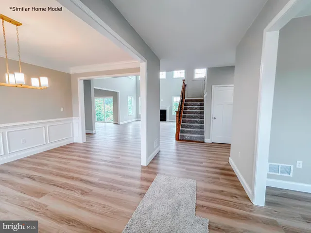 a view of a hallway with wooden floors and stairs