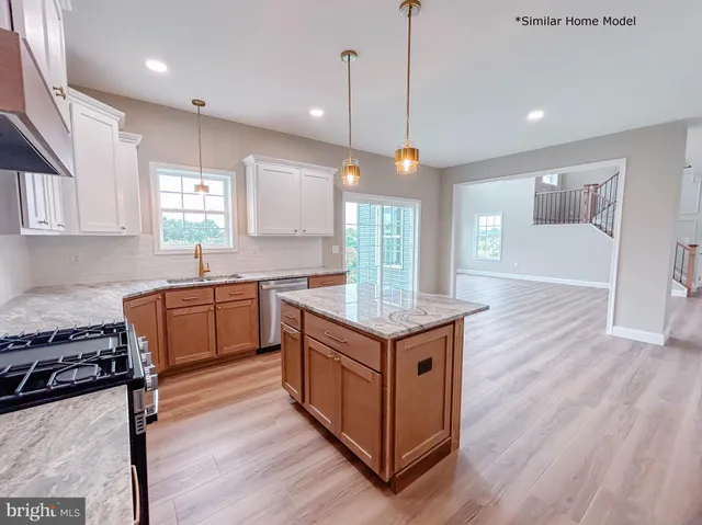 a kitchen with a stove a sink and wooden floor