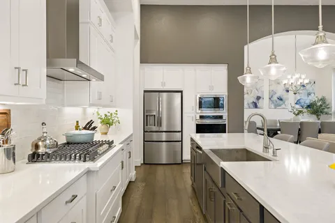 a kitchen with a sink a stove and chairs