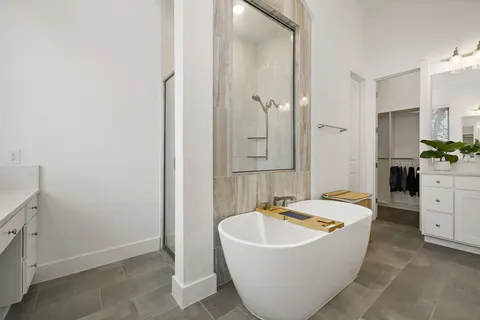 a bathroom with a tub sink and mirror