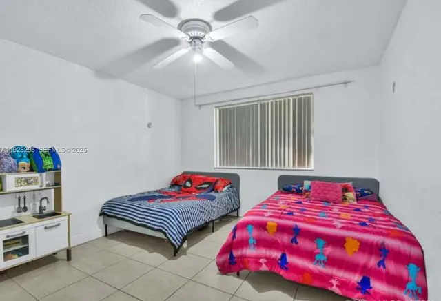 a bedroom with two bed and a chandelier