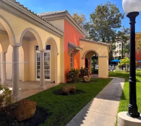 a view of a brick house with a large windows and a yard