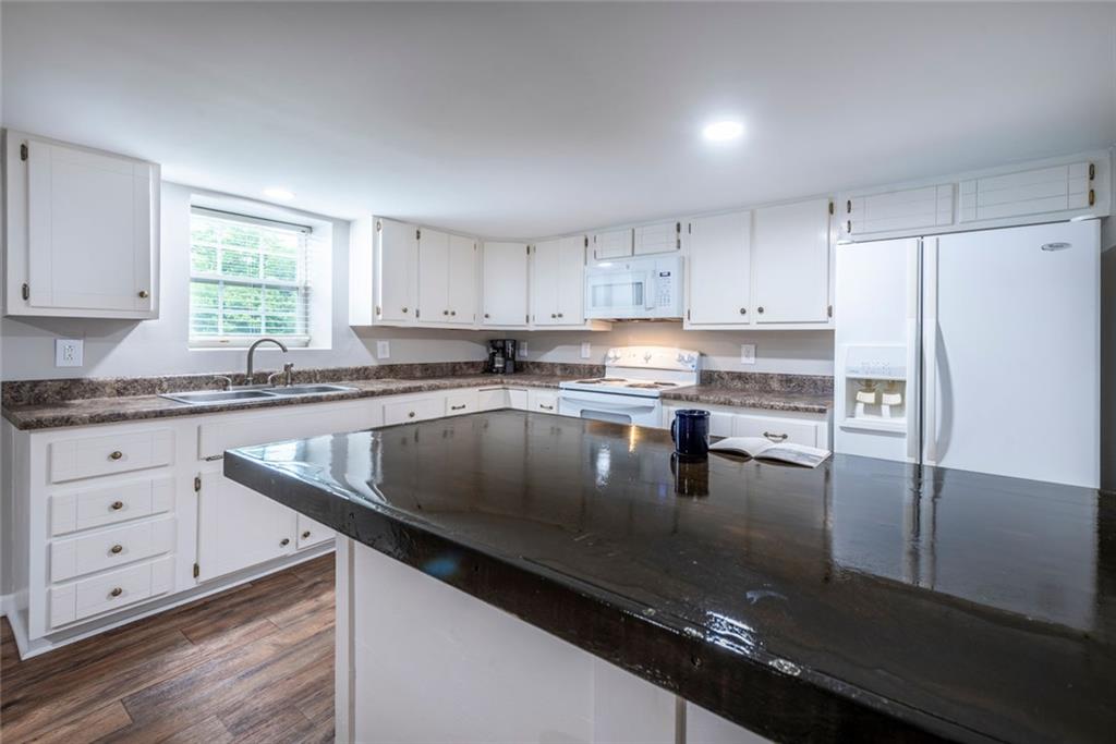 2508 Maple Road Southeast Rome, GA 30161 - Photo 28 of 55 a kitchen with granite countertop a sink stainless steel appliances and white cabinets