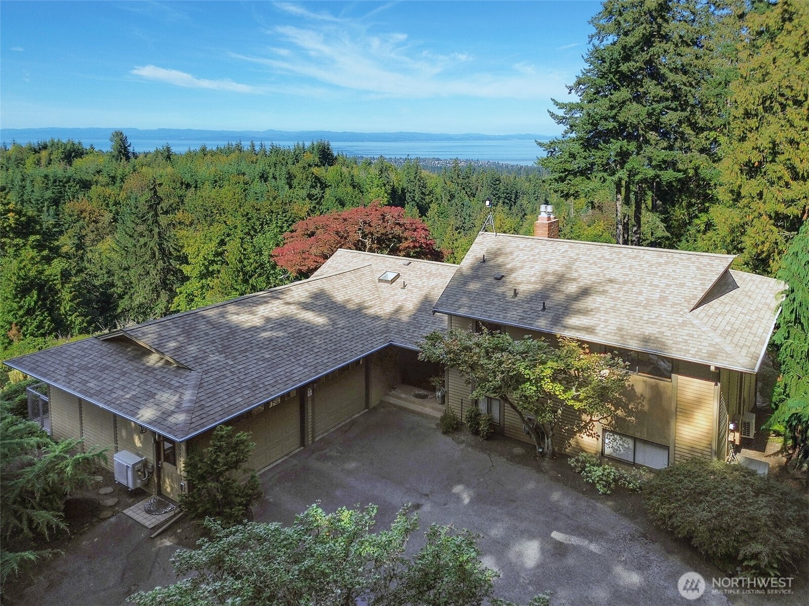 an aerial view of a house with a yard and large tree