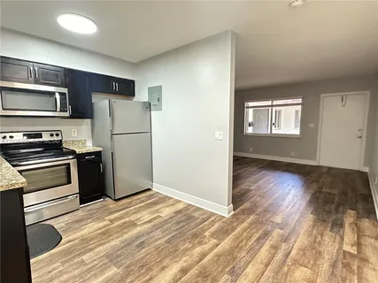 a kitchen with a refrigerator and a stove top oven
