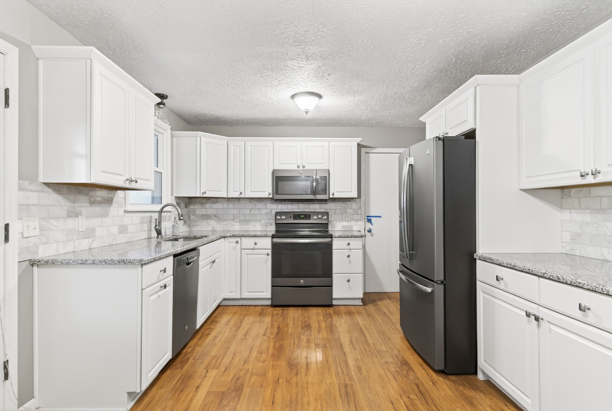 115 Calista Road White House, TN 37188 - Photo 24 of 38 a kitchen with granite countertop white cabinets and stainless steel appliances