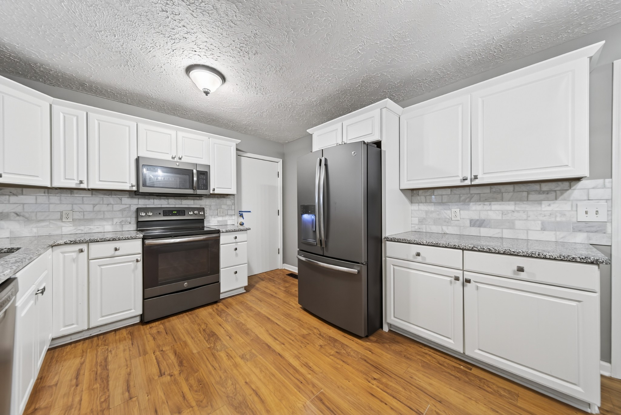 115 Calista Road White House, TN 37188 - Photo 25 of 38 a kitchen with granite countertop a refrigerator stove and white cabinets