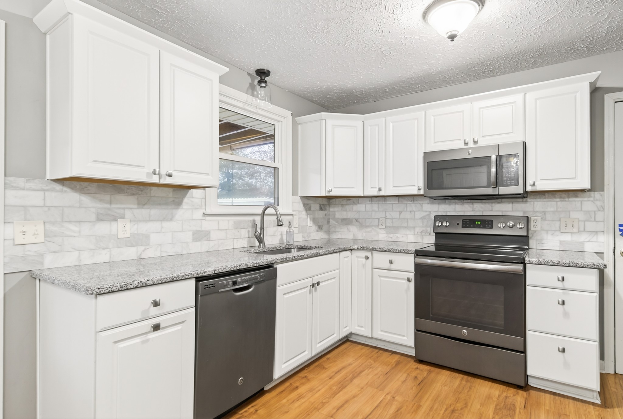 115 Calista Road White House, TN 37188 - Photo 26 of 38 a kitchen with granite countertop wooden cabinets and a stove