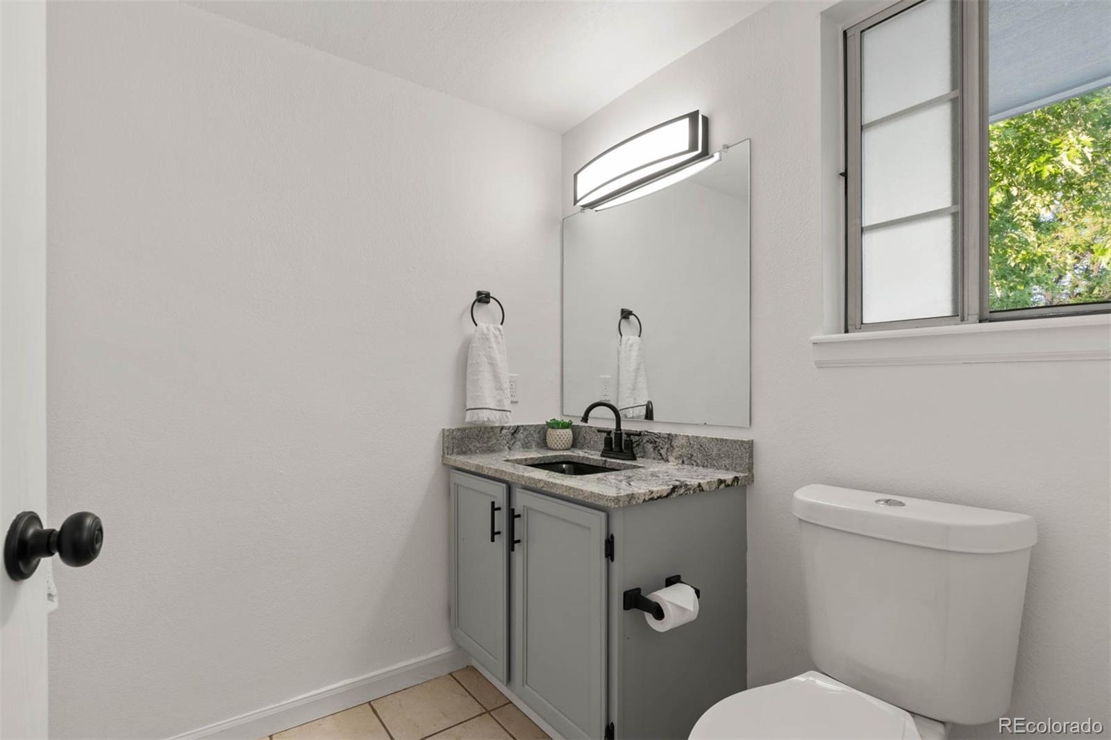 6283 Xavier Street Arvada, CO 80003 - Photo 12 of 36 a bathroom with a granite countertop sink toilet and mirror